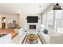 Bright living room with large windows and a stylish fireplace, virtually staged at 3435 Macland Rd, Powder Springs, GA 30127