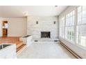 Sunlit living room featuring a charming brick fireplace and large windows at 3435 Macland Rd, Powder Springs, GA 30127