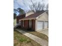 Well-maintained home featuring a two-car garage, brick accents, and a tidy lawn at 956 S Deshon Rd, Lithonia, GA 30058