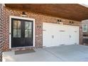 A double door garage is made with brick and painted white doors with black accents at 140 Rigby Ne St, Marietta, GA 30060