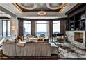 Modern living room with a curved sofa, floor-to-ceiling windows offering city views, and stylish circular chandeliers at 3376 Peachtree Ne Rd # 56, Atlanta, GA 30326