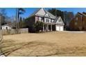 View of house featuring an expansive lawn, two-car garage and mature trees, ideal for outdoor enjoyment at 4845 Dartford Dr, Powder Springs, GA 30127