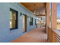 Spacious front porch featuring a wood floor, modern lighting fixtures, and elegant architectural details at 561 Ashburton Ave, Decatur, GA 30032