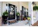 Inviting front porch decor with a magnolia wreath, potted ferns, and American flag accents at 613 Hemlock Ct, Villa Rica, GA 30180