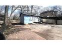 A backyard featuring a building with damaged siding and overgrown weeds at 1429 Funston Se Ave, Atlanta, GA 30315