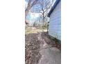 View of the side yard with overgrown landscaping and a brick walkway at 1429 Funston Se Ave, Atlanta, GA 30315