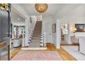 Elegant foyer with hardwood floors, staircase, decorative lighting, and views into adjoining rooms at 80 26Th Nw St, Atlanta, GA 30309
