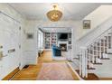 Bright foyer with hardwood floors, a staircase, and an open view to the living room with built-in bookshelves at 80 26Th Nw St, Atlanta, GA 30309