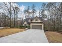 Beautiful home featuring an attached garage, long driveway, and basketball court, nestled amongst mature trees at 2845 Hickory Cir, Snellville, GA 30078