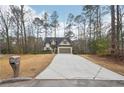 Inviting home exterior with long driveway and well-maintained lawn surrounded by lush greenery at 2845 Hickory Cir, Snellville, GA 30078