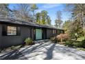Close-up of home with a slate gray exterior, a turquoise door, and manicured front yard at 3240 Pinestream Nw Rd, Atlanta, GA 30327