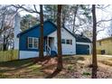 A charming home with a chimney and a front lawn surrounded by lush trees at 40 Cumberland Dr, Rex, GA 30273