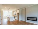 Open-concept living space featuring a modern kitchen, hardwood floors, and an electric fireplace at 4818 Floydwood Ln, Mableton, GA 30126