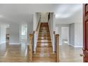 Open foyer with hardwood floors, staircase, and views into adjacent rooms at 4840 Pisgah Rd, Cumming, GA 30028