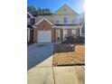 Two-story townhome featuring a brick and yellow exterior, attached garage, and lawn at 553 Rockbridge Trl, Stone Mountain, GA 30083
