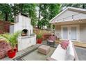 Inviting backyard patio with a wood-burning oven, comfortable seating, and ambient string lights for outdoor enjoyment at 1584 Carroll Nw Dr, Atlanta, GA 30318