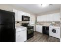 Bright kitchen with modern appliances, white cabinets, and a convenient washer/dryer setup for easy chores at 1584 Carroll Nw Dr, Atlanta, GA 30318