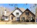 Two-story home featuring stone and siding with a manicured lawn and inviting entrance at 2410 Glade Overlook, Cumming, GA 30041