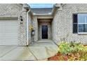 Close-up of a home's front entry with a black door, brick facade, and manicured landscaping at 811 Pineberry Ct, Grayson, GA 30017