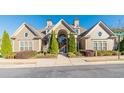 Community clubhouse featuring manicured landscaping, evergreen trees, and a central covered entryway at 1445 Archstone Dr, Cumming, GA 30041