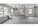 Open-concept kitchen featuring a peninsula with modern grey cabinets, quartz countertops, and stainless steel appliances at 2945 Catalina Dr, Decatur, GA 30032