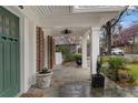 Charming covered front porch with stone flooring, brick accents, and stylish lighting fixture at 755 Adair Ne Ave, Atlanta, GA 30306