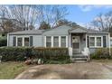 Charming single-story home with blue siding and landscaped front yard and an inviting front porch at 1054 Shepherds Ne Ln, Atlanta, GA 30324
