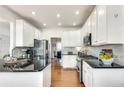 Modern kitchen with white cabinetry, stainless steel appliances, granite countertops, and hardwood floors at 5915 Vintage Oaks Pass, Mableton, GA 30126