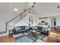 Bright living room featuring high ceilings, a staircase, comfortable seating, and hardwood floors at 5915 Vintage Oaks Pass, Mableton, GA 30126