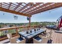 Spacious wooden deck with dining table, chairs, and a pergola, offering stunning views of the surrounding landscape at 5915 Vintage Oaks Pass, Mableton, GA 30126