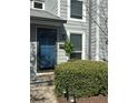 View of the front entrance featuring a blue door and manicured bushes at 1063 Riverbend Club Se Dr, Atlanta, GA 30339