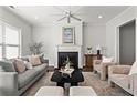 Cozy living room with a fireplace, stylish seating, ceiling fan, and natural light from the window at 13 Ganel Ln, Alpharetta, GA 30009