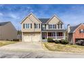 Attractive two-story home with vinyl siding, brick accents, covered porch, and a two-car garage at 203 Overlook Ct, Dallas, GA 30157