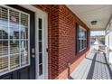 Welcoming brick front porch with storm door, painted deck, and stylish exterior lighting at 203 Overlook Ct, Dallas, GA 30157