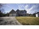Exterior view of a two-story home with a two-car garage and a long driveway at 70 Woodcliff Way, Covington, GA 30014