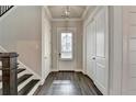 Bright entryway with hardwood floors, closet and a front door with shuttered window at 1043 Harvest Park Ln, Suwanee, GA 30024