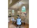 Dining room with vaulted ceilings, modern chandelier, seating for four and an arched window at 118 Hawkstone Way, Alpharetta, GA 30022
