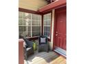 Cozy front porch featuring a seating area and a bright red front door at 118 Hawkstone Way, Alpharetta, GA 30022
