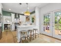 Bright kitchen featuring white cabinets, stainless steel appliances, and a cozy breakfast bar at 3595 Evonvale Overlook, Cumming, GA 30041