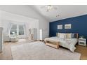 Spacious main bedroom with ample natural light, hardwood floors and blue accent wall at 3595 Evonvale Overlook, Cumming, GA 30041