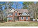 Charming two-story brick home with a manicured lawn and blue shutters gives a welcoming curb appeal at 100 Hamilton Glen Ct, Fayetteville, GA 30215