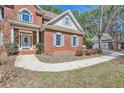Close-up of a charming two-story brick home showing front yard, walkway and attached garage with shed at 100 Hamilton Glen Ct, Fayetteville, GA 30215