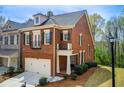 Brick townhome showcasing the side exterior, a well-manicured lawn, and mature trees at 1111 Newpark View Pl, Mableton, GA 30126