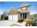 Two-story home with stacked stone and vinyl siding plus a manicured lawn and two car garage at 665 Sable View Ln, Atlanta, GA 30349