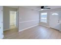 Bright room with ceiling fan, fresh paint, leading to a bathroom and front door at 6716 Browns Mill Ferry Dr, Lithonia, GA 30038