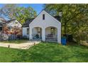 Charming white brick home with an arched covered front porch and lush green lawn at 1184 Metropolitan Sw Pkwy, Atlanta, GA 30310