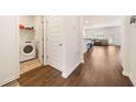 Hallway features wood floors and leads to a laundry room and the open living area at 2030 Vidalia Court, Dacula, GA 30019