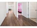 Bright hallway featuring wood flooring, white trim, and doors to bedrooms and living areas at 2030 Vidalia Ct, Dacula, GA 30019
