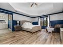 Spacious main bedroom with a tray ceiling, hardwood floors, and a cozy sitting area at 6119 Fairlong Nw Run, Acworth, GA 30101