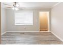 Bright living room with modern ceiling fan, neutral paint, and beautiful gray wood floors at 6202 Humphries Hill Rd, Austell, GA 30106